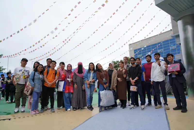 Visitors arriving under strings of bunting at the festival entrance