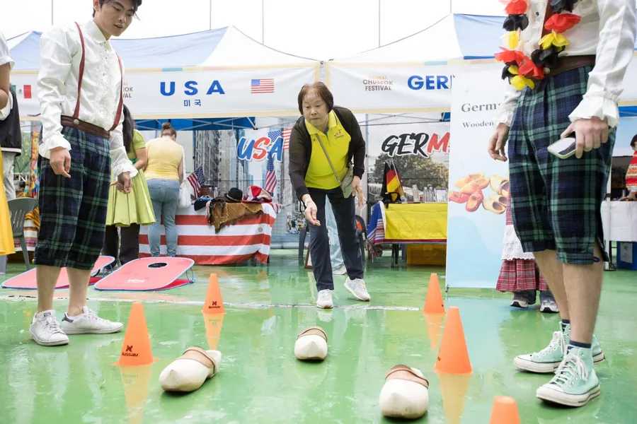 Visitors playing a bean-bag game between the country booths