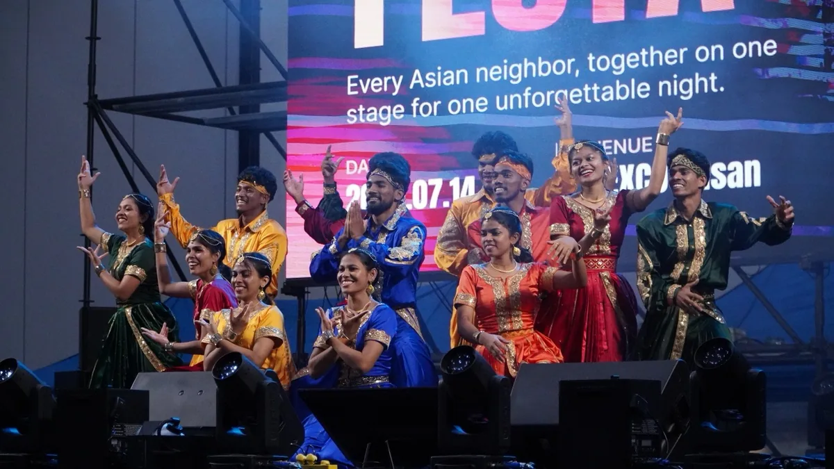 A dance troupe in colourful traditional dress performing together on the main stage