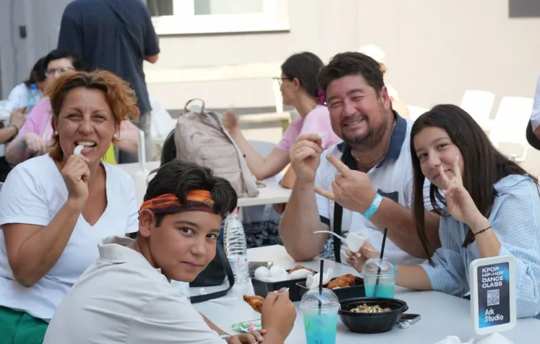A family sharing street food and drinks around an outdoor table