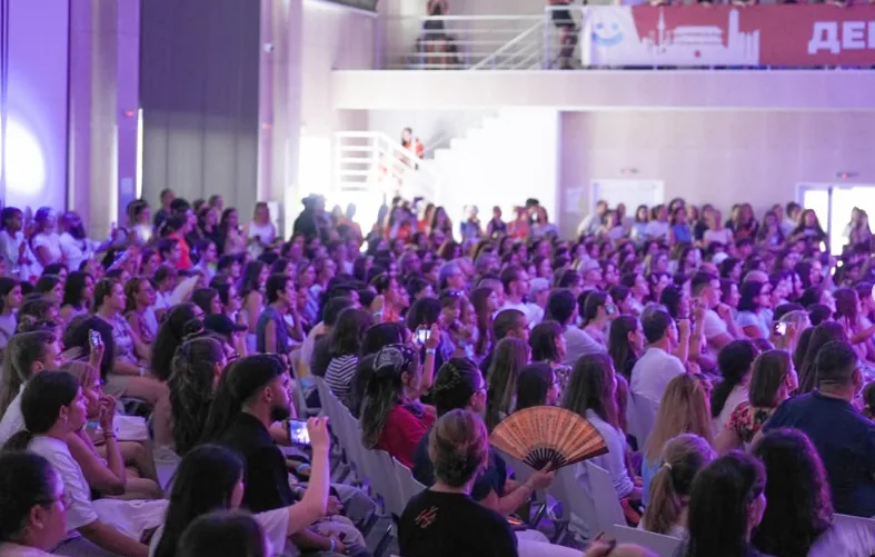 A packed hall of guests from many countries watching the show together